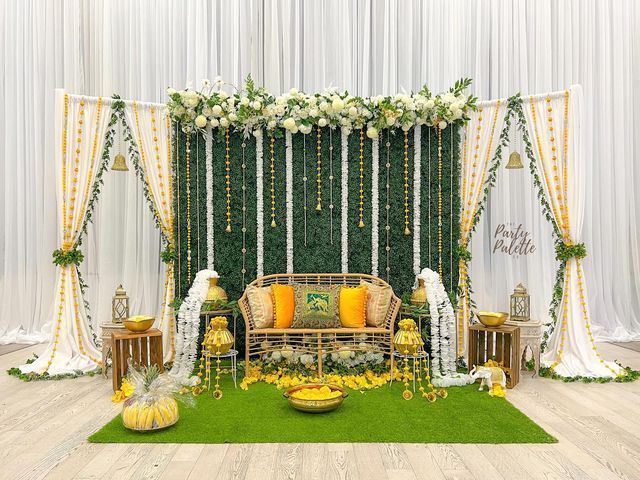 Colourful mehndi ceremony decoration with drapes and floral elements